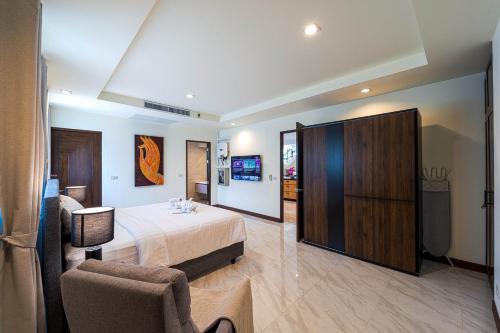 a hotel room with a bed and a chair at Luxury 5 Bedroom Villa Close to Beach SRS in Hua Hin