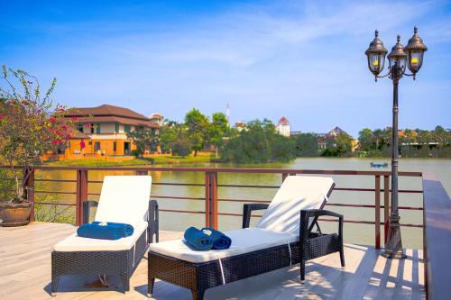 two chairs and a street light next to a river at Luxury 5 Bedroom Villa Close to Beach SRS in Hua Hin