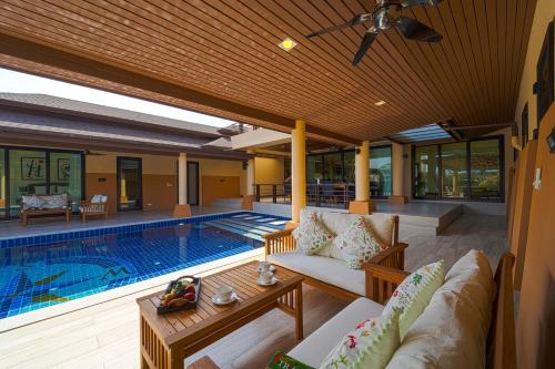 a patio with a swimming pool with a couch and a table at Luxury 5 Bedroom Villa Close to Beach SRS in Hua Hin
