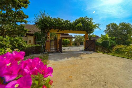 a house with a gate and pink flowers at Luxury 5 Bedroom Villa Close to Beach SRS in Hua Hin