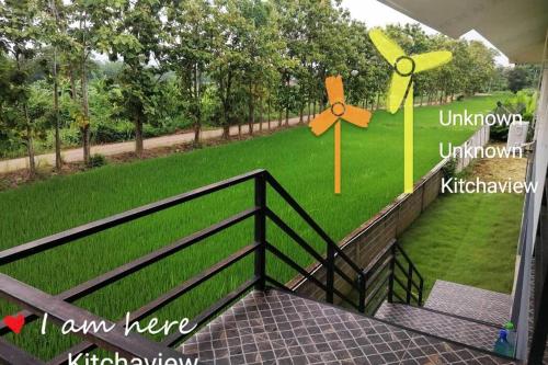 a porch with a fence and a field of grass at กิติ์ชาวิว วิลล่า in Ban Nang Lae