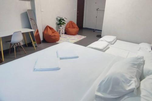 a room with two white beds and orange chairs at กิติ์ชาวิว วิลล่า in Ban Nang Lae