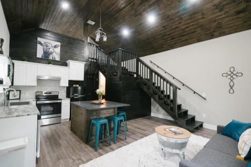 a kitchen with a staircase and a living room at Creed's Cottage at Four Oaks in New Braunfels