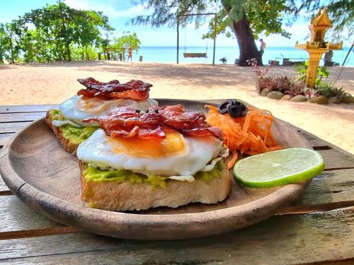 a plate of food with eggs and vegetables on the beach at SunBoo Beach Bungalows in Koh Rong Sanloem