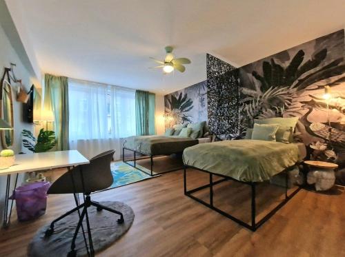 1 dormitorio con 2 camas y escritorio. en Light Jungle Suite: Seltersweg Netflix TV & Jumanji, en Giessen