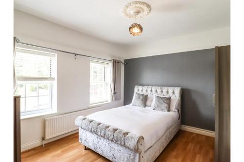 a bedroom with a bed and a large window at 6BD Vacation Home with Indoor Pool in Canvey Island