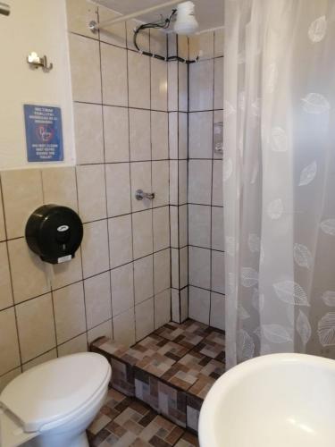 un baño con inodoro y ducha en Global Airport Inn FREE Shuttle, en Guatemala