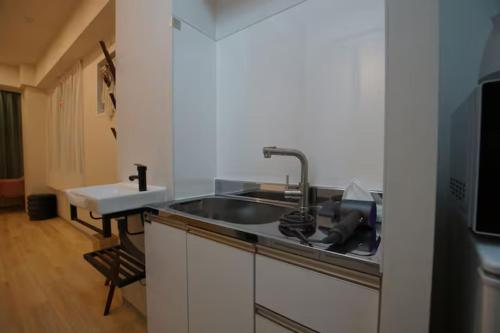 a kitchen with a sink and a microwave at Tokyo Guest 浜町 in Tokyo