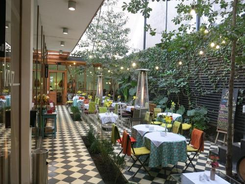 um restaurante com mesas e cadeiras num piso de xadrez em Dpto 3P - Barrio Italia - Santiago de Chile em Santiago