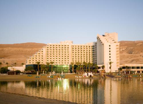 a hotel with its reflection in a body of water at Leonardo Club Hotel Dead Sea - All Inclusive in Ein Bokek