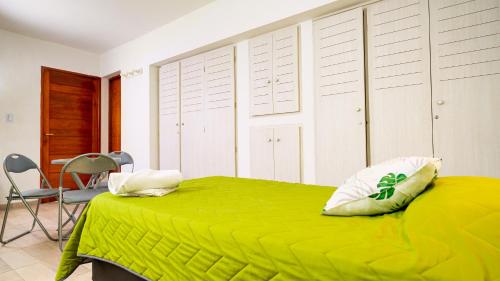 um quarto com uma cama verde e uma cadeira em Bambú Hotel em Chepes