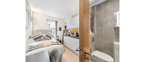 a small bedroom with a bed and a shower at The *Best* Airbnb for Transport in London! Promise in London