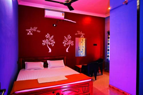 a bedroom with a bed with red and purple lights at Auro Galaxy Pondy with Swimming Pool in Kottakupam