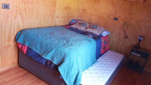 - un petit lit dans un coin de chambre dans l'établissement El Paraíso de Los Cisnes, à Quellón