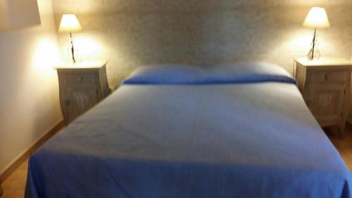 トラーパニにあるCasa Vacanza la Fiabaのベッドルーム1室(青いベッド1台、ナイトスタンド2台付)
