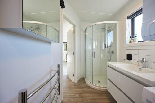 a white bathroom with a sink and a shower at Extremely Central in Kaikoura
