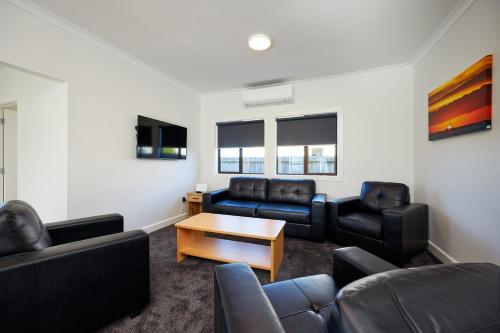 a living room with couches and a table at Central | Beach Nearby | Parking - KK27622 in Kaikoura