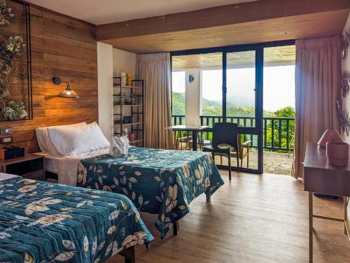 a hotel room with two beds and a balcony at Ponderosa Golf and Country Club in Puerto Galera