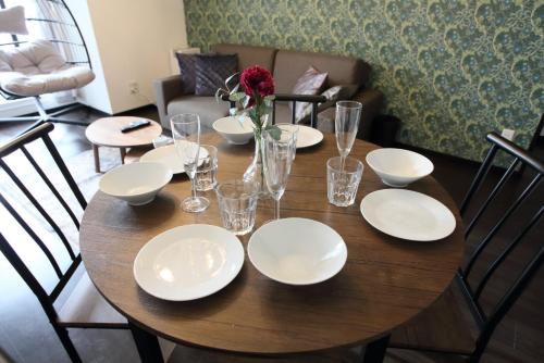 a wooden table with white plates and glasses on it at サンコート４０２ in Kita-sanjō
