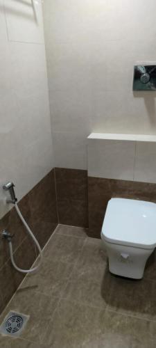 a bathroom with a white toilet and a sink at CORAL STAYS INN in Vijayawāda