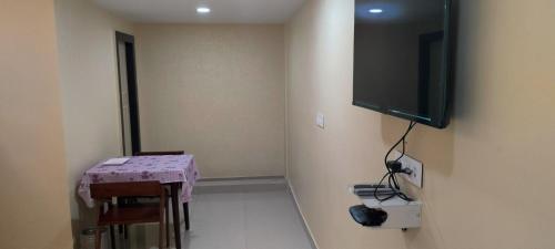 um quarto com uma mesa e uma televisão na parede em CORAL STAYS INN em Vijayawāda