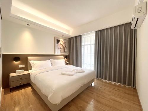 a bedroom with a large white bed and a window at SKY 31 Luxurious Condominium in Phnom Penh