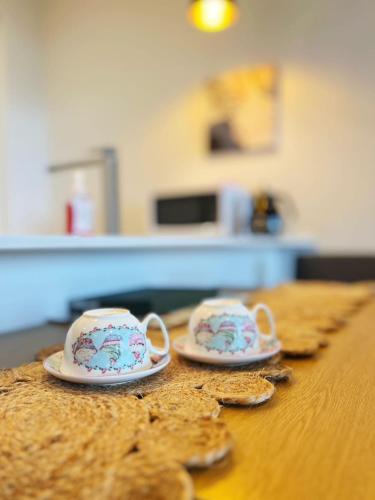 two tea cups sitting on top of a table at Auckland Birkenhead BNB in Auckland