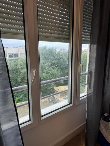 a pair of windows with blinds in a room at Kremlin-Bicêtre in Le Kremlin-Bicêtre