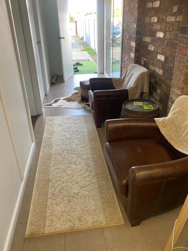 a living room with couches and a rug at Broadway Apartment in West Wyalong