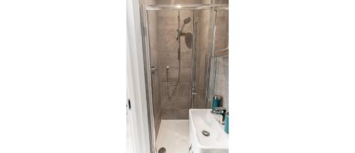 ein Bad mit einer Dusche und einem Waschbecken in der Unterkunft NEW: Bright & Stylish Perfect Studio for 2 in London