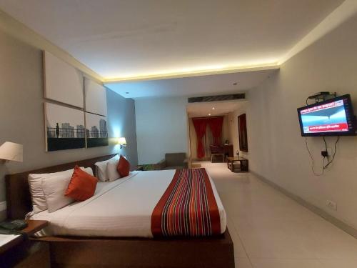 Habitación de hotel con cama y TV en Orbit Hotel en Bāghdogra