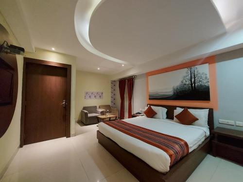 a hotel room with a large bed and a couch at Orbit Hotel in Bāghdogra