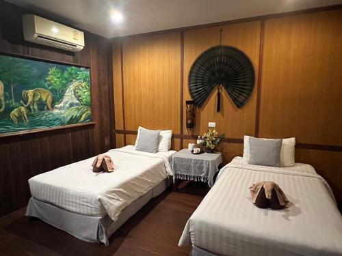 a room with two beds and a painting on the wall at V-View Beach Resort in Ban Tai