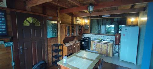 a kitchen with a refrigerator and a table in a cabin at Nirvana Ecolodge - Private accomodations in the beach side of Atlantic forest in Florianópolis