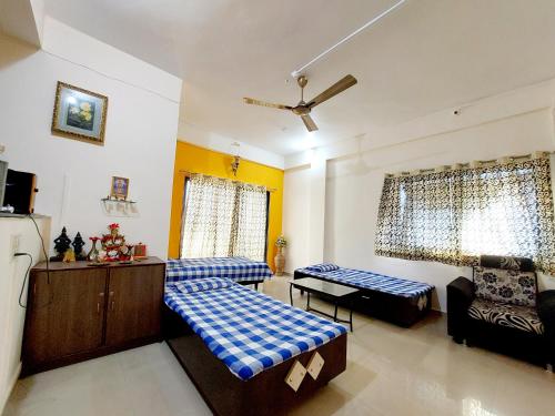 a living room with two beds and a couch at Muktangan Home, Kolhapur in Kolhapur