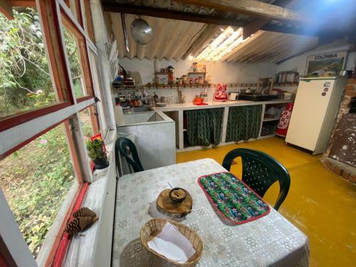 a table and a kitchen with a table and a table at Cabaña Colibri naturaleza vista Laguna de la Cocha in Pasto
