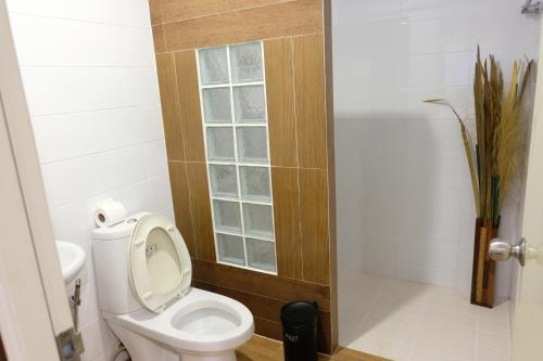a bathroom with a toilet and a window at V-View Beach Resort in Baan Tai