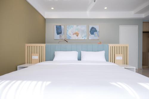 una camera da letto con un grande letto con due cuscini bianchi di Zenstay Sdn Bhd a Bukit Mertajam