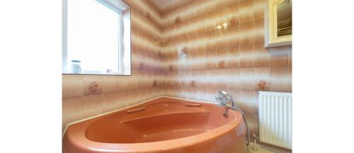 a red tub in a bathroom with a window at Casual and Cozy 5 BD Home in Canvey Island in Hadleigh