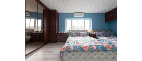 1 dormitorio con cama y espejo en Casual and Cozy 5 BD Home in Canvey Island en Hadleigh