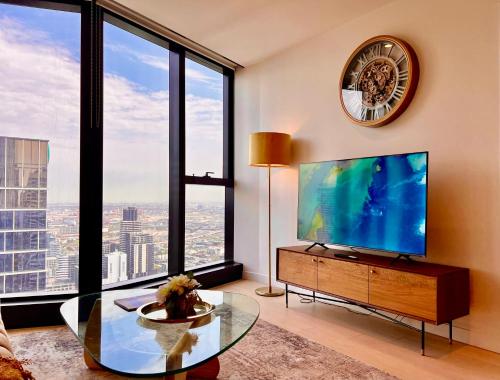 a living room with a large tv and large windows at High rise top view 2bed2bath in Melbourne