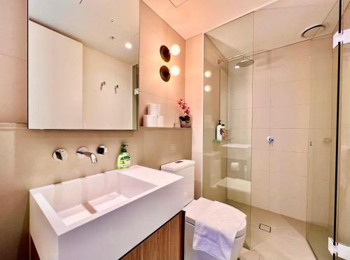 a bathroom with a white sink and a shower at High rise top view 2bed2bath in Melbourne