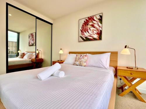 a bedroom with a large bed with a desk and a mirror at High rise top view 2bed2bath in Melbourne