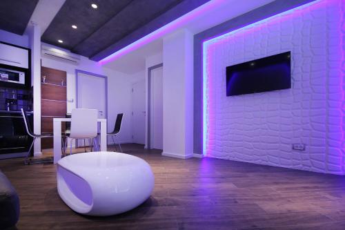 a room with a white chair and a tv on a brick wall at Apartments Belgrade in Belgrade