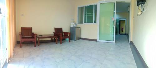 a hallway with chairs and a table and a glass door at Palm Kaew Resort Krabi in Krabi