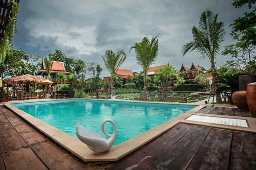 a swimming pool at a resort with a swan statue at Ayutthaya retreat in Phra Nakhon Si Ayutthaya