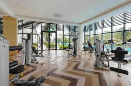 een fitnessruimte met loopbanden en cardio-apparatuur in een kamer met ramen bij Greenfield Residence Comfort Stay Near sunway pyramid, sunway college, one academy, taylors uni in Petaling Jaya