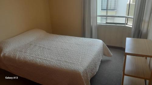 - une chambre avec un lit blanc et une fenêtre dans l'établissement Inn's Arequipa, à Arequipa