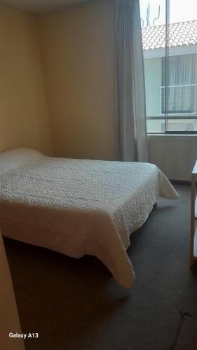 - une chambre avec un lit et une grande fenêtre dans l'établissement Inn's Arequipa, à Arequipa