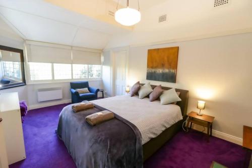sypialnia z dużym łóżkiem i fioletowym dywanem w obiekcie The Gables - Circa 1880 - Classic Bowral Property w mieście Bowral